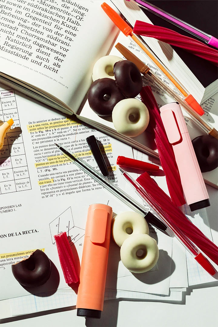 Photography of a messy desk with snacks and books